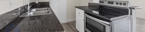 A kitchen with a stove, sink, and cabinets.