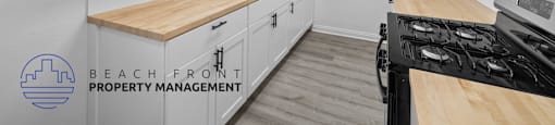 A kitchen with white cabinets and a wooden countertop.