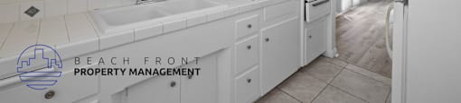 a white kitchen with white cabinets and a white sink