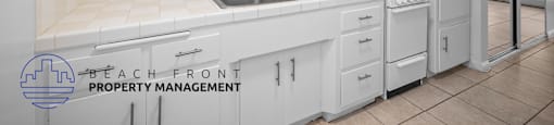 a white kitchen with white cabinets and a sink
