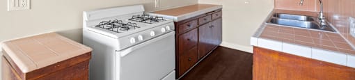 A kitchen with a white stove and wooden cabinets.