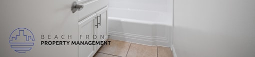 a white bathroom with a tub and a sink and a shower