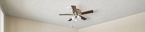 A room with a ceiling fan and carpeted floor.