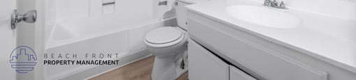 A white bathroom with a toilet, sink, and bathtub.