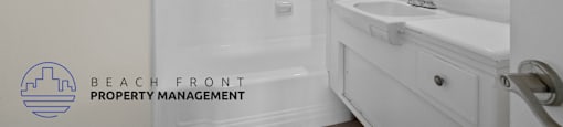 a white bathroom with a shower and a sink and a mirror
