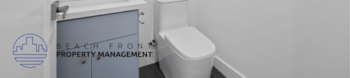 A white toilet sits next to a sink in a small bathroom.