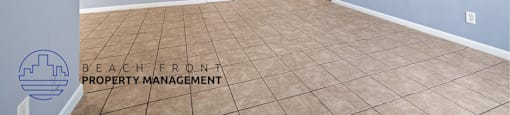 A room with tile flooring and a logo for Beach Front Property Management.