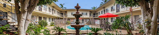 A courtyard with a fountain and trees.