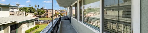 the view from the balcony of a apartment building with a long balcony with windows