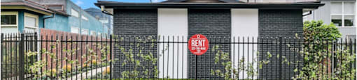 a gate with a red sign on it in front of a house
