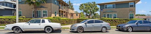 Two cars parked in front of a building with the logo "BEACH FRONT PROPERTY MANAGEMENT" on the bottom left.