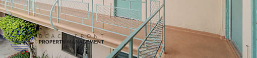 A balcony with a metal railing and a green door.