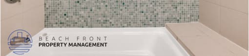 a bathroom with a bath tub and a blue tiled wall
