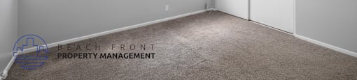 the living room of a house with white walls and carpet
