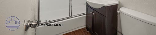 A small bathroom with a sink, mirror, and a glass shower door.