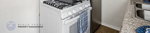 A kitchen with a white stove top oven and a black refrigerator.
