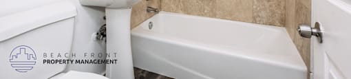 A bathroom with a white sink and bathtub.
