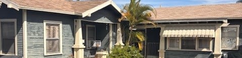 A house with a blue front yard and a white fence.