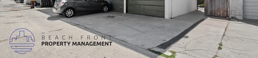 a white building with a garage and a car parked in front of it