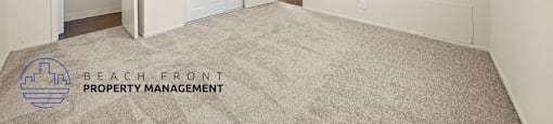 A spacious room with a ceiling fan and carpeted floor.