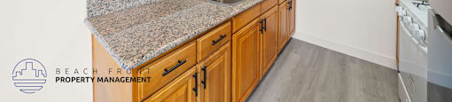 A kitchen with granite countertops and wooden cabinets.