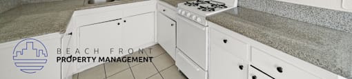 A kitchen with white cabinets and a stove top oven.