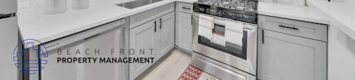 a white kitchen with stainless steel appliances and white cabinets