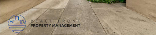 an empty walkway between two buildings in a beach front property management