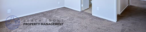A room with a carpeted floor and two doors, one of which is open.