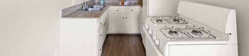 A white kitchen with a stove and cabinets.