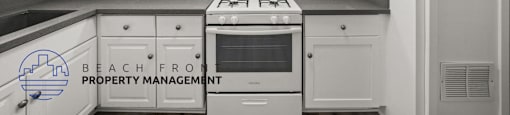 A kitchen with white cabinets and a stove top oven.