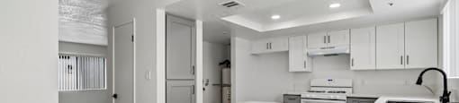 A modern kitchen with white cabinets and a white countertop.