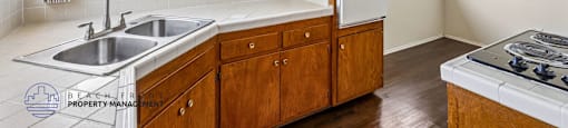 A kitchen with wooden cabinets and a stainless steel sink.
