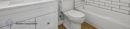 A white bathroom with a sink, toilet, and bathtub.