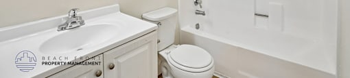 A white bathroom with a sink, toilet, and bathtub.