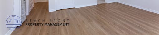 a renovated living room with white walls and wood flooring