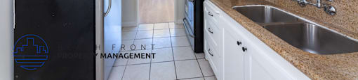 a kitchen with white cabinets and a black refrigerator