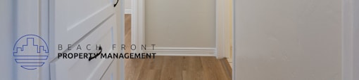 a white hallway with a white door and a white shelf on the wall