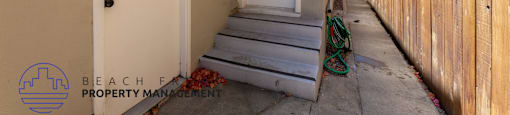 the front door of a house with stairs and a fence