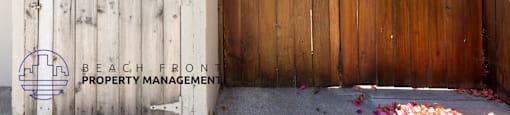 a fence and a trash can in front of a house