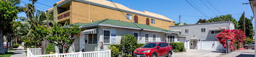 a red car parked in front of a house on a street