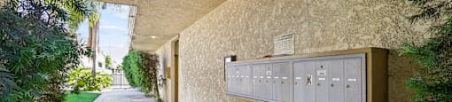 A long hallway with a wall of mailboxes on the side.