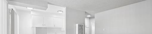 A white kitchen with a refrigerator, sink, and cabinets.