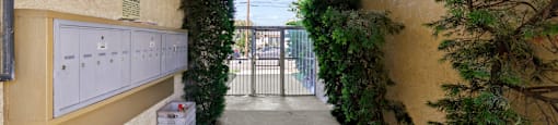 A long hallway with a white trash can and a gate in the distance.