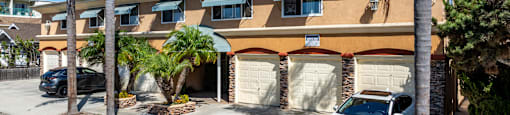 A white car is parked in front of a building with the sign "BEACH FRONT PROPERTY MANAGEMENT".