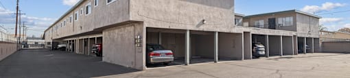 A parking lot with a building and a car parked in front of it.