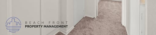 A hallway with white doors and a logo for Beach Front Property Management.