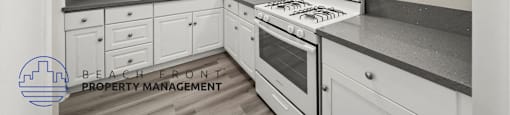 A kitchen with white cabinets and a stove top oven.