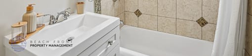 A bathroom with a tiled wall and a window.