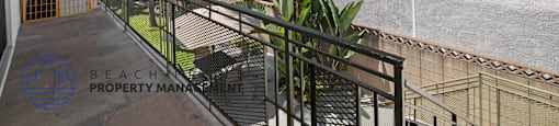 a balcony with a view of a house and a garden
